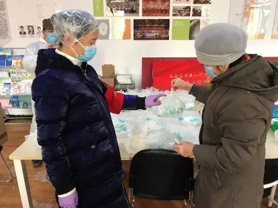 為樓棟分發(fā)口罩，并為包裝袋消毒